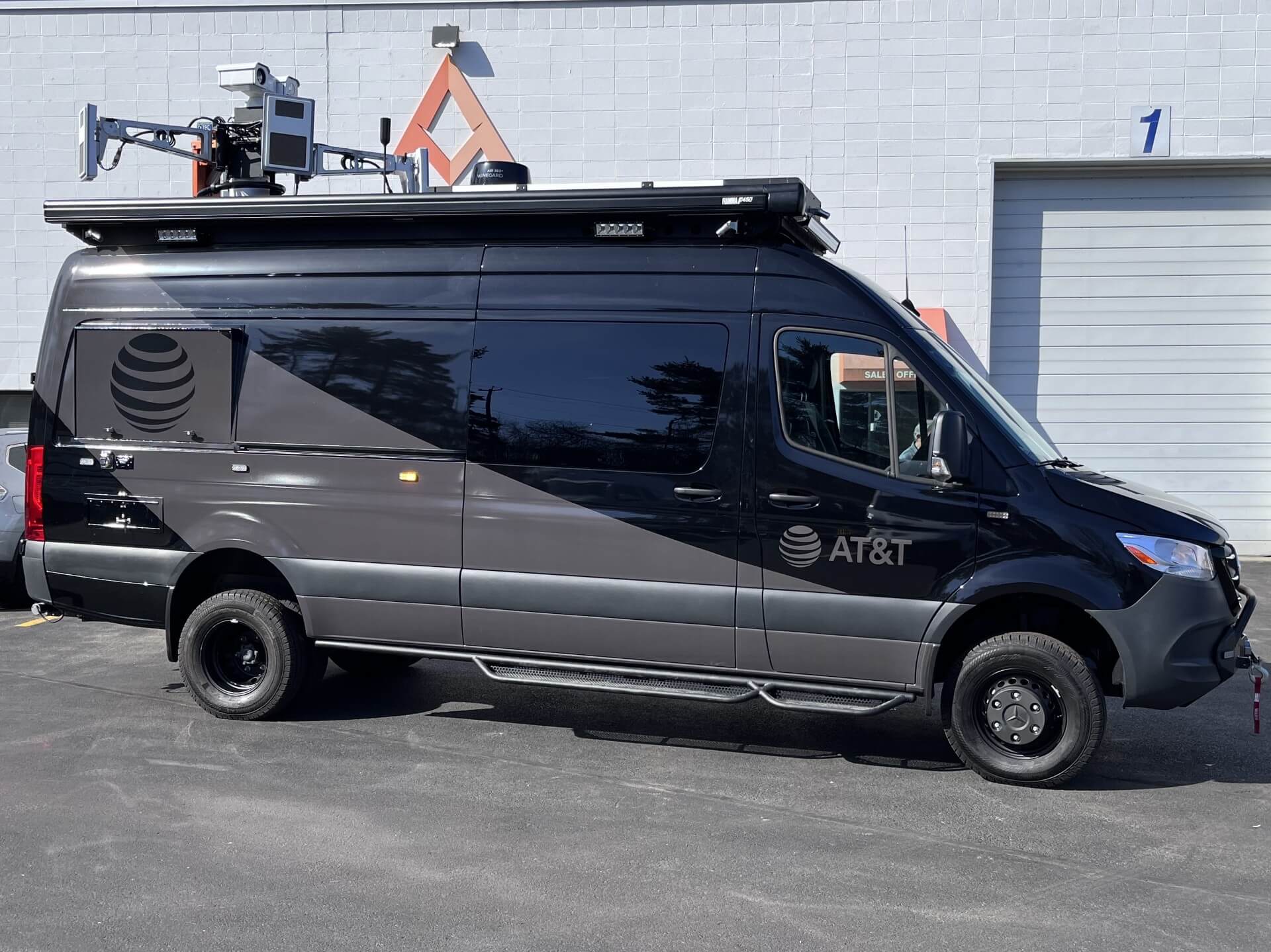 A black van with a subtle AT&S logo upfitted with counter-unmanned aerial system (C-UAS) technology